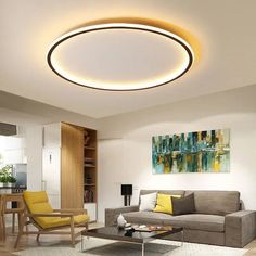 a living room filled with furniture and a round light fixture above the coffee table on top of a rug