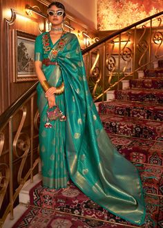 a woman in a green sari standing on the stairs with her hand on her hip