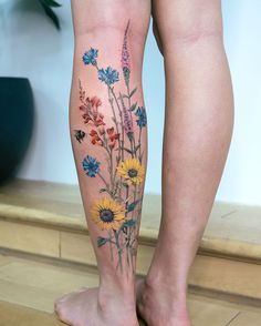 a woman's leg with flowers painted on it