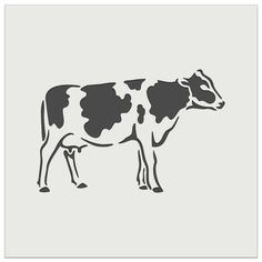 a black and white cow standing on top of a gray floor next to a wall