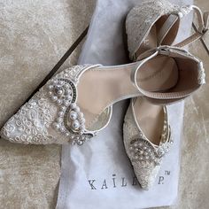 a pair of white shoes sitting on top of a table next to a napkin and bag