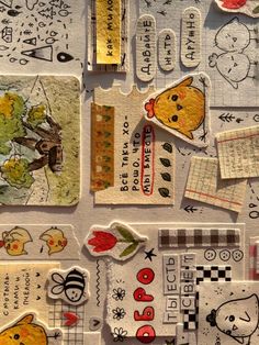 various stickers and tags are arranged on a table with paper cut out to look like children's drawings