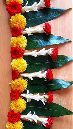 flowers arranged on top of each other in the shape of long stems with green leaves