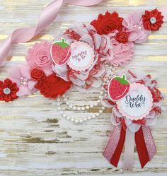 two red and pink paper flowers on top of each other with words daddy to be