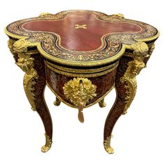 an ornately decorated wooden table with gold trimmings on the top and sides