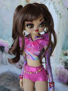 a close up of a doll with very long hair and big eyes wearing a pink outfit