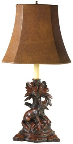 a lamp that is sitting on top of a wooden base with a brown shade over it