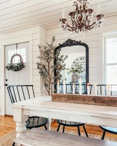 a dining room table with chairs and a mirror