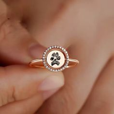 a close up of a person holding a ring with a dog paw on it