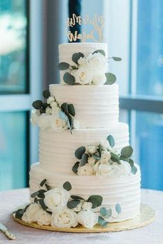 a wedding cake with white flowers and greenery on top is featured in the magazine