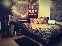 a bedroom with zebra print bedding and lights on the wall above the headboard