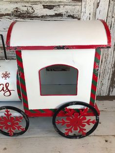 a small white and red toy truck with snowflakes on it's side