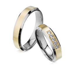 two gold and silver wedding rings with diamonds on each side, set against a white background