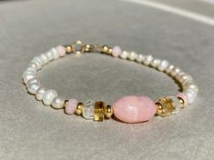 PINK OPAL BRACELET HANDMADE WITH FRESHWATER PEARLS AND GOLD FILLED Freshwater Pearl bracelet with Pink Opal, Aquamarine, Citrine and Gold filled beads. This bracelet comes in a length of 17,5cm.  If you need another length, please let me know when you order. Here you can find all my other bracelets: https://www.etsy.com/de/shop/ilkajewels?ref=seller-platform-mcnav&section_id=24365956 I send all my jewelry pieces nicely packed in a jewelry bag. MATERIAL -freshwater pearl, 4mm -Gold filled beads a Pink Beaded Jewelry Birthday Gift, Pink Beaded Jewelry For Birthday Gift, Pearl Bracelet With Natural Round Beads, Natural Stone Pearl Bracelet With Round Beads, Hand-strung Pearl Bracelet Gift, Pink Gemstone Bracelets For Gift, Rose Quartz Beaded Bracelet Gift, Handmade Spiritual Pearl Bracelet As Gift, Pink Opal Beaded Bracelets With Round Beads As Gift