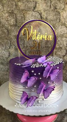 a purple and white cake with butterflies on it