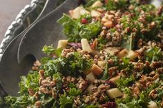 a salad with apples, nuts and greens in a bowl