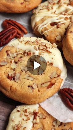 cookies with white icing and pecans are on the table next to each other