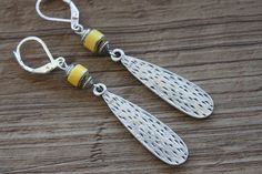 Yellow Silver Earrings Dangle Drop Earrings Boho Earrings Boho Jewelry Gift for her Gift for women Christmas Gift Color : yellow brown ceramic tubes beads Finish of the main pieces : Antique hammered Silver Plated Metal (34x8mm) Length : 2,5 inches including the Sterling Silver lever Backs Ear wire : Sterling Silver leverback and sterling silver findings Available in turquoise : https://www.etsy.com/listing/203810163/boho-turquoise-earrings-silver-earrings?ref=shop_home_active_1 Silver Earrings Yellow Bohemian Metal Earrings, Handmade Yellow Bohemian Teardrop Earrings, Yellow Teardrop Bohemian Jewelry, Boho Turquoise, Rustic Earrings, Boho Chic Earrings, Dangle Earrings Boho, Brown Ceramic, Spring Earrings