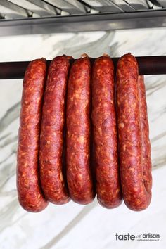 four sausages are hanging on a rack