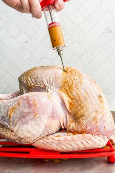 someone is using a meat thermometer to cut up a turkey on a red tray