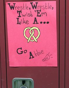 a pink paper sign on a red locker with writing underneath it that says wrestle, wrestle, i wish'm like a go able