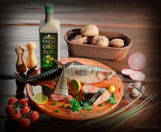 an assortment of food items displayed on a wooden table with a bottle of olive oil