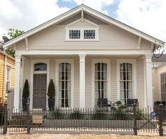 a small white house with black iron fence