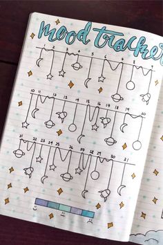 an open notebook with doodles on it and the words mood tracker written in blue