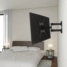 a flat screen tv mounted to the wall above a bed