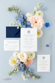 the wedding stationery is laid out on top of each other, with flowers and greenery