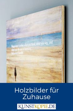 a painting hanging on the wall next to a blue and white sign that says hozbilder fur zuhausse