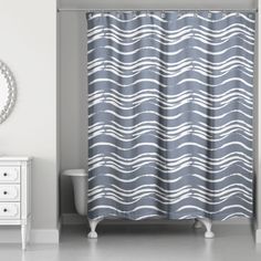 a bathroom with a shower curtain, mirror and dresser in front of the tubtub