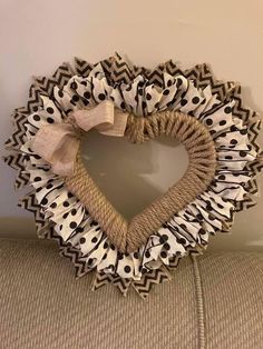 a heart shaped wreath with black and white polka dots hanging on the side of a wall