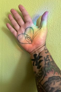 a person's hand with tattoos on it and an all seeing eye drawn on the palm