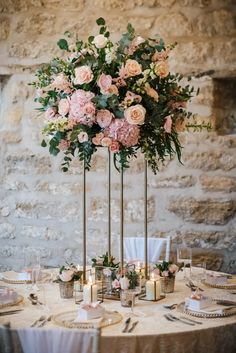 the centerpieces are adorned with pink flowers and greenery, along with candles