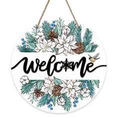 a welcome sign hanging from a rope with flowers and pineconis on it,