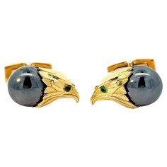 Crafted with the utmost precision and infused with regal splendor, these 18k yellow gold cufflinks exude an aura of strength and sophistication. At their heart lies the majestic visage of an eagle, its fierce gaze captured in intricate detail and rendered with exquisite artistry. The head of the eagle, fashioned from lustrous 18k yellow gold, commands attention with its noble bearing and commanding presence. Every curve and contour is meticulously crafted to convey the bird of prey's unmistakable majesty, from the curve of its beak to the texture of its feathers. Nestled below the eagle's gaze rests a hematite cabochon, its smooth surface a canvas for the interplay of light and shadow. The deep hue of the hematite exudes an aura of mystery and allure, drawing the eye and adding an element Luxury Yellow Gold Clip-on Jewelry, Formal Yellow Gold Cabochon Jewelry, Luxury Polished Finish Jewelry For Formal Occasions, Luxury Formal Jewelry With Polished Finish, Designer Formal Jewelry Hallmarked, Luxury 14k Gold Clip-on Jewelry, Luxury Polished Jewelry For Business, Luxury Polished Business Jewelry, Luxury Polished Finish Business Jewelry