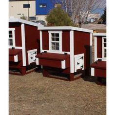 three red and white chicken coops with windows