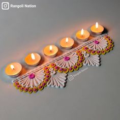 an intricately decorated diya with lit candles