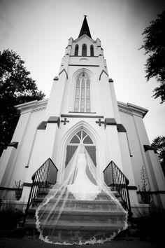 black and white photo of bride in front of church