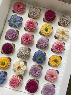 the cupcakes are decorated with flowers in different colors and sizes on top of each other