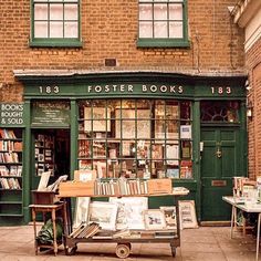 a bookshop with many books on display in front of the storefront and tables outside