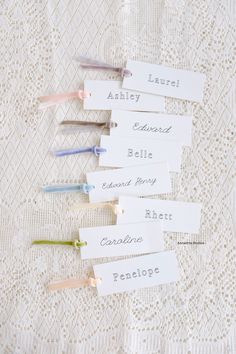 several name tags are placed next to each other on a lace tablecloth with crocheted doily