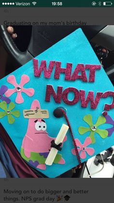 a blue graduation cap with the words what now? written on it and a cartoon character holding a microphone