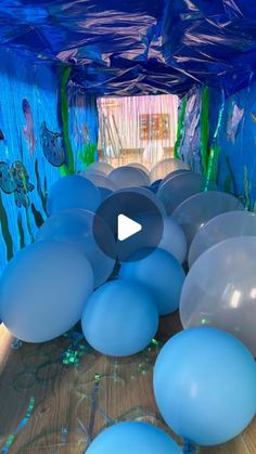 there are many blue and white balloons in the room that looks like it is floating