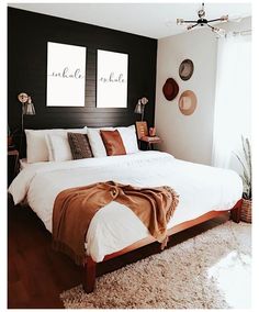 a large bed sitting in a bedroom on top of a wooden floor next to a window