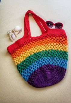 a crocheted bag with sunglasses on the side and a pair of eyeglasses next to it