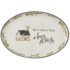 a white plate with green leaves and a house on the side that says love grows best