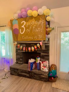 a birthday party with balloons and decorations on the mantle, including an ice cream parlor sign