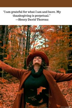 a woman with her arms outstretched in the air, wearing a red hat and coat